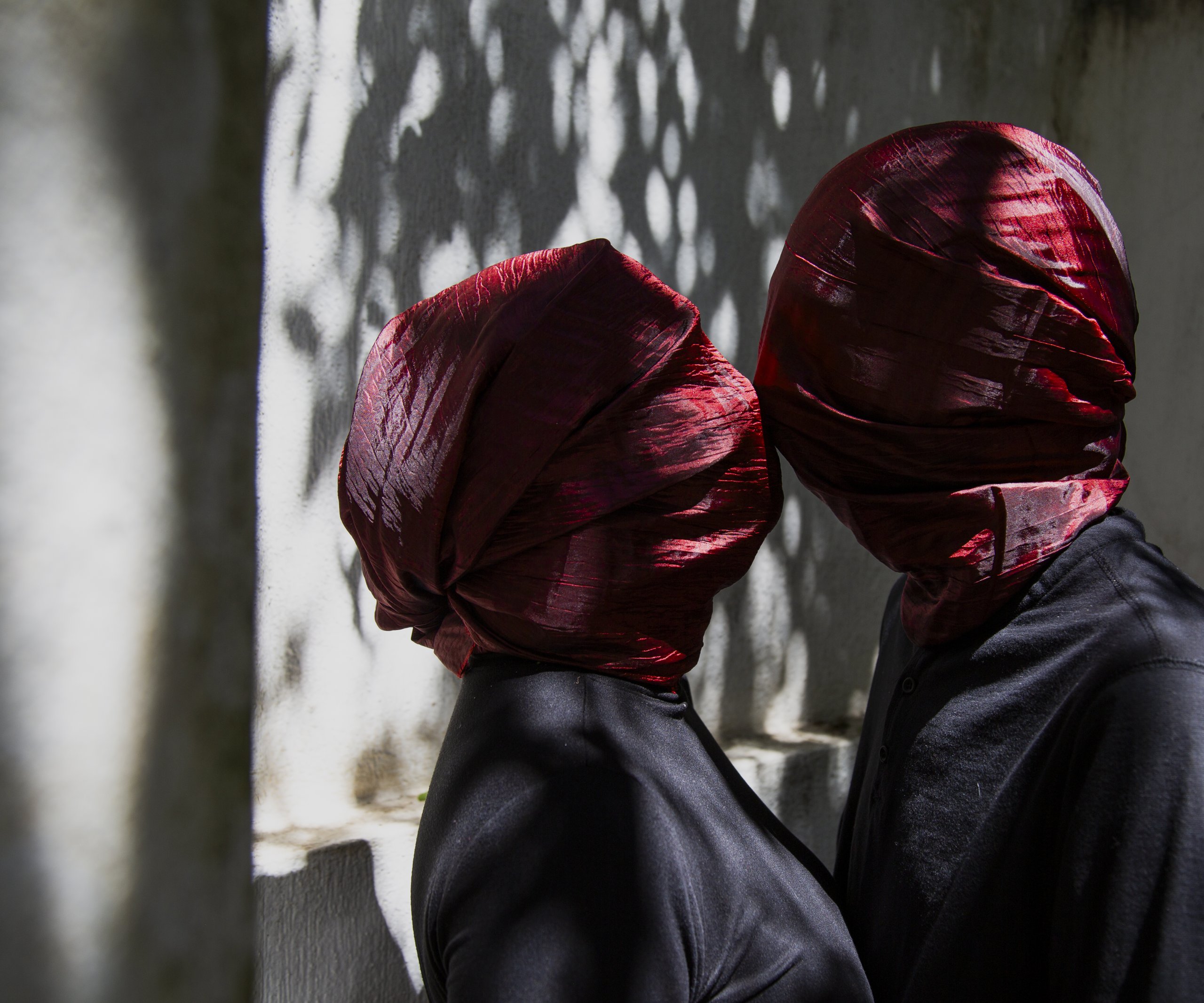 Portada de Introducción a la Fotografía: dos figuras con la cabeza cubierta por una tela roja, © Gabie Grajeda